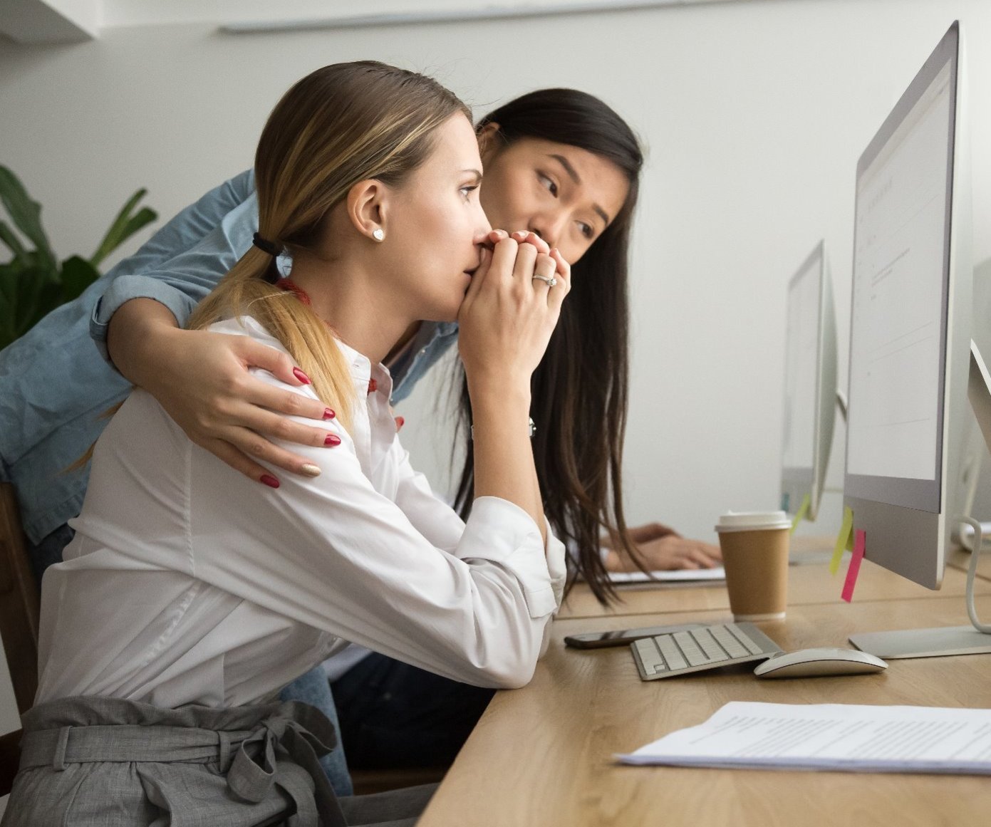 woman consoling another female colleague at her desk